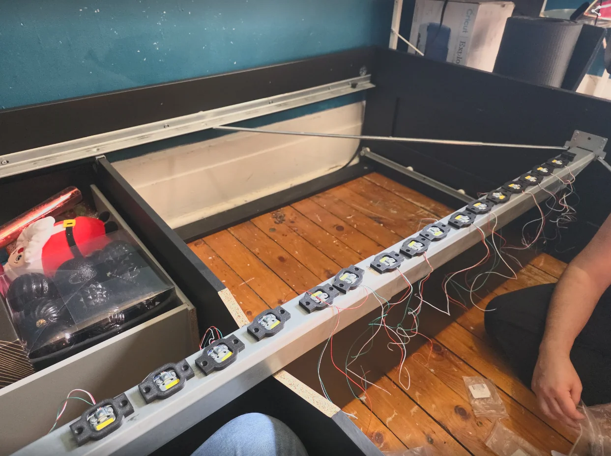 Sixteen load cells mounted along the spine of a bed frame